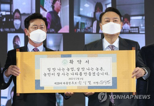 지난 달 4일 윤석열 당선인이 한국농업경영인중앙연합회에서 개최한 '대선 농정비전 발표회'에서 확약서를 들고 기념촬영을 하고 있다. <연합뉴스>